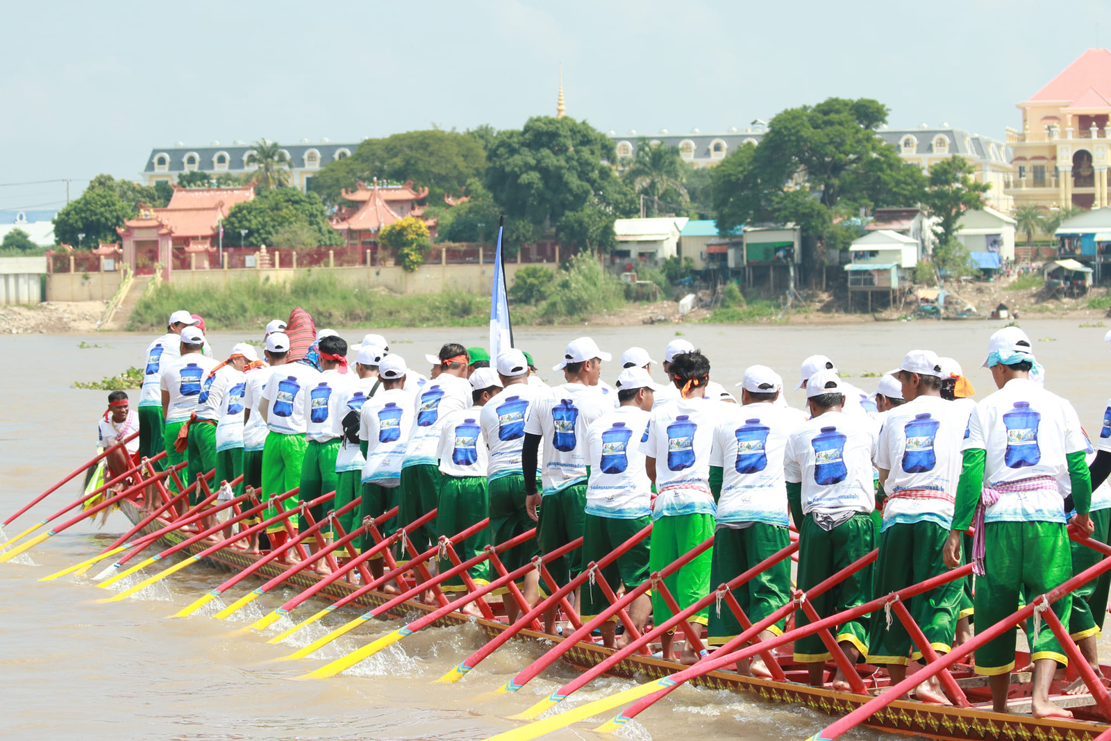 A Cambodian community rowing together as water drops form a current toward a school