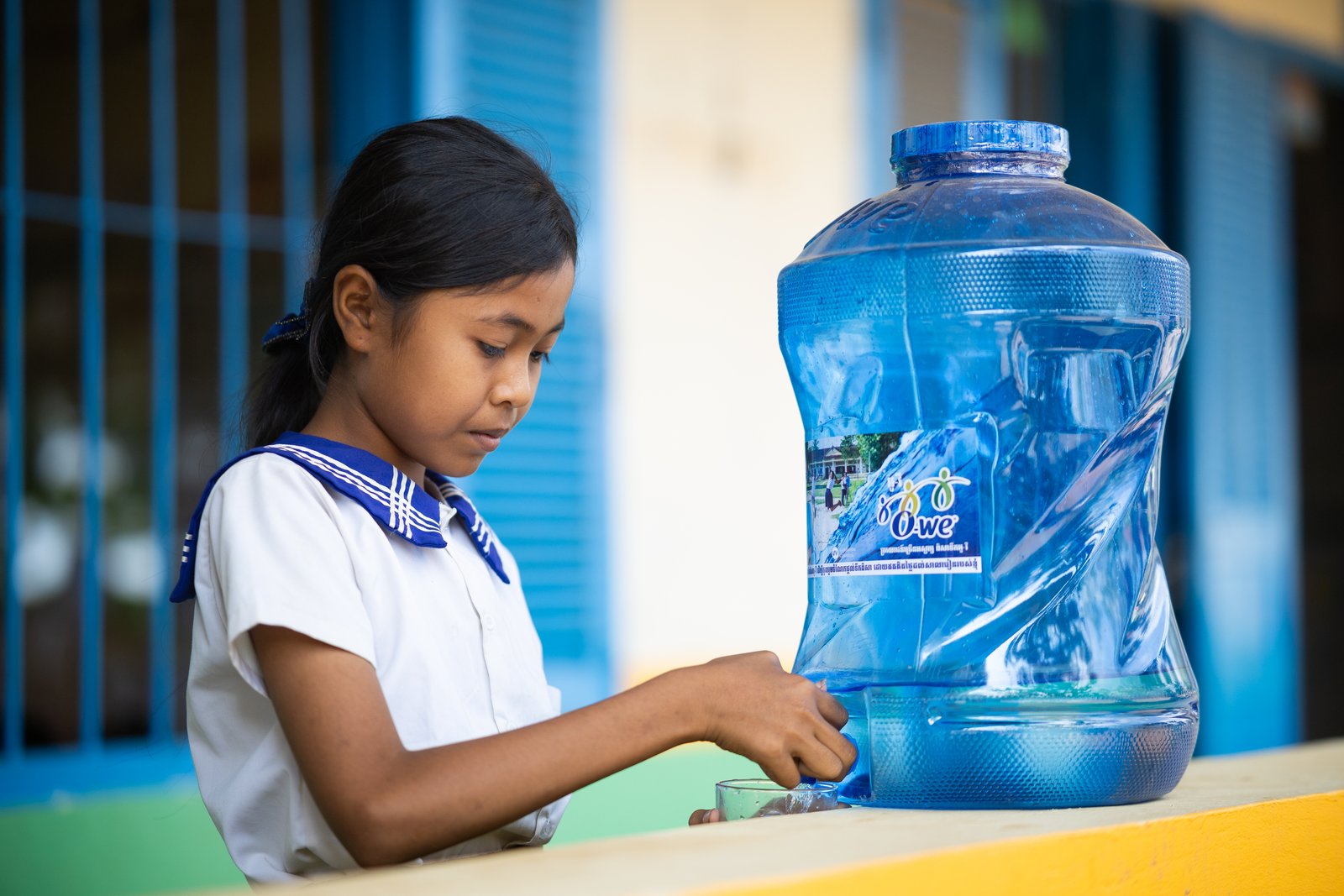 Cambodian schoolchildren filling reusable bottles with safe drinking water